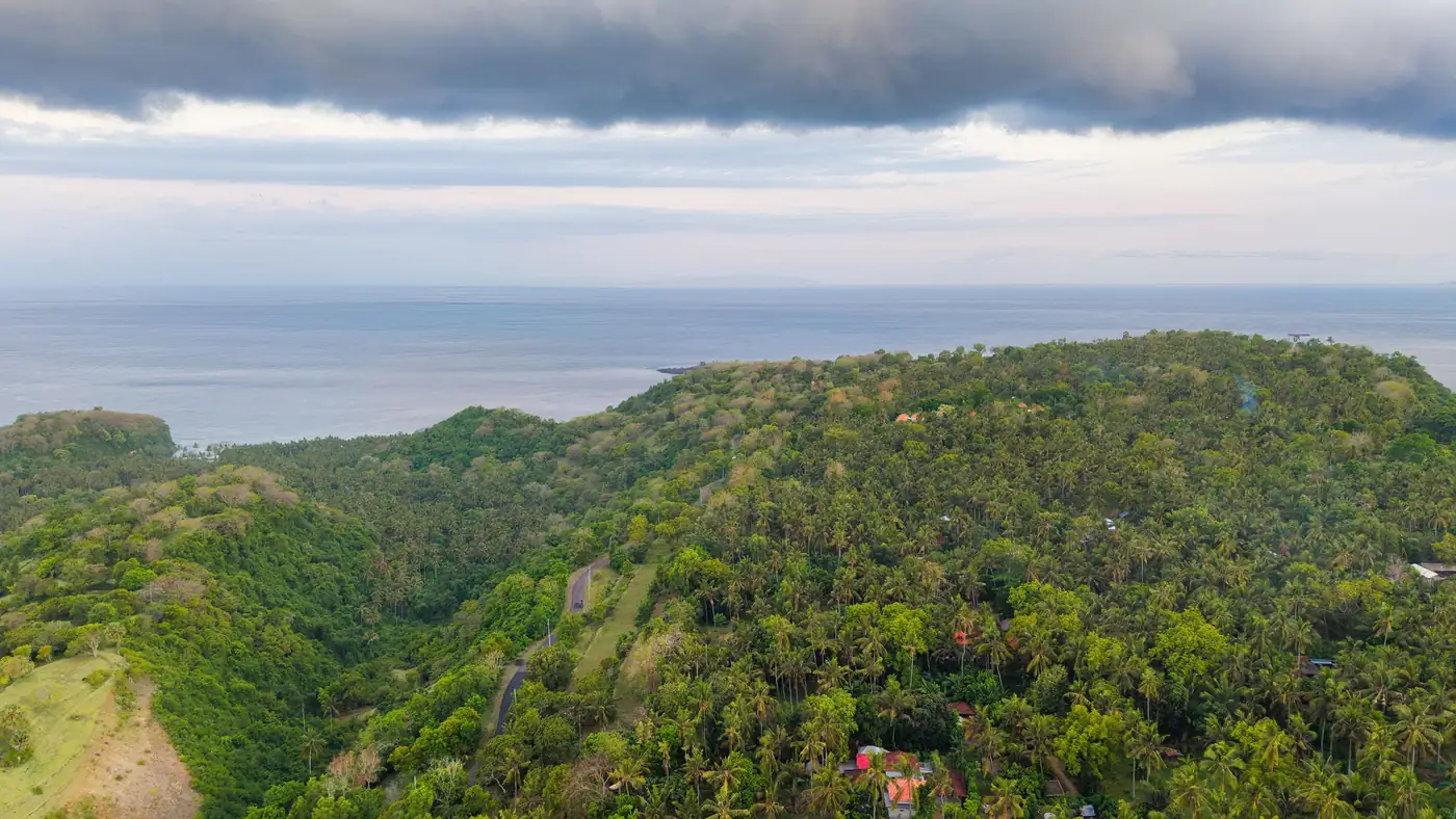 Illustrative photo: green hills sloping down to the sea