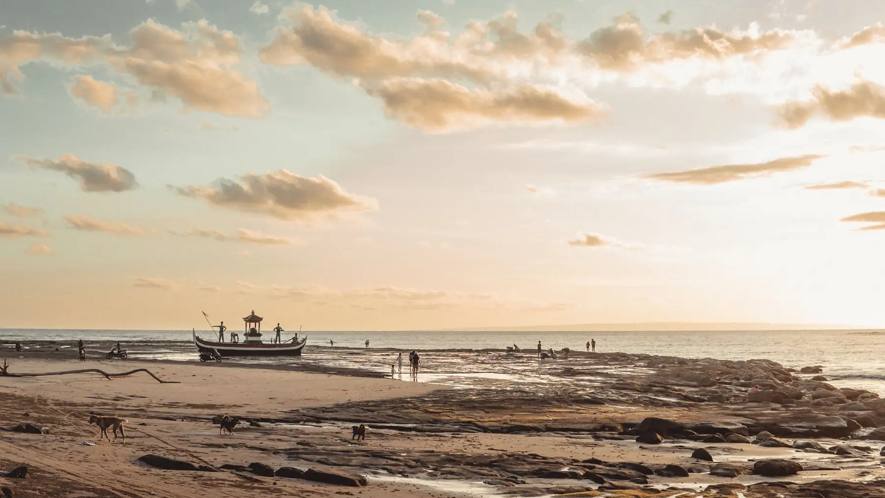 Illustrative photo of a quiet beach at sunrise with a fishing boat