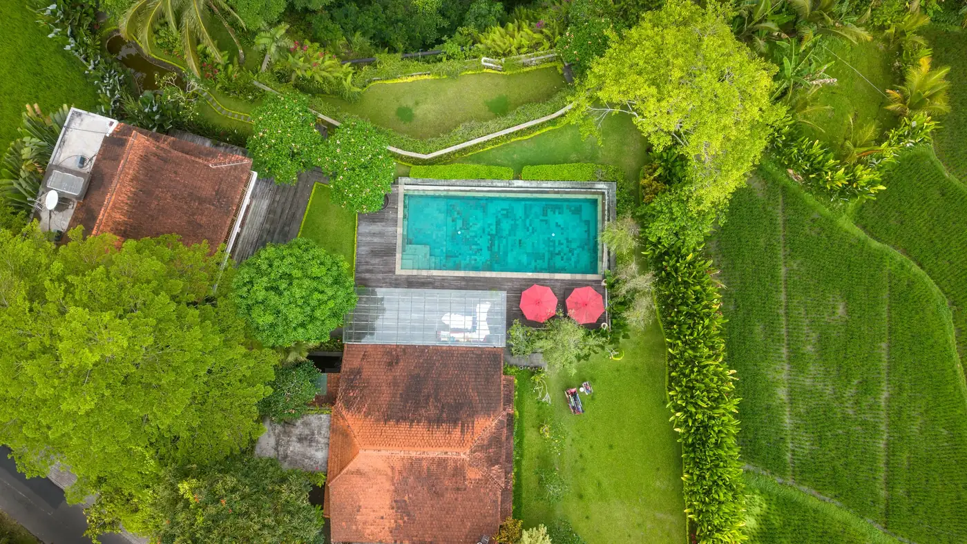 Illustrative photo: aerial view of a villa and pool between rice fields